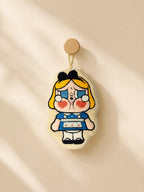 Cute cream and blue character hand towel hanging from a wooden wall peg in a warm minimalist bathroom