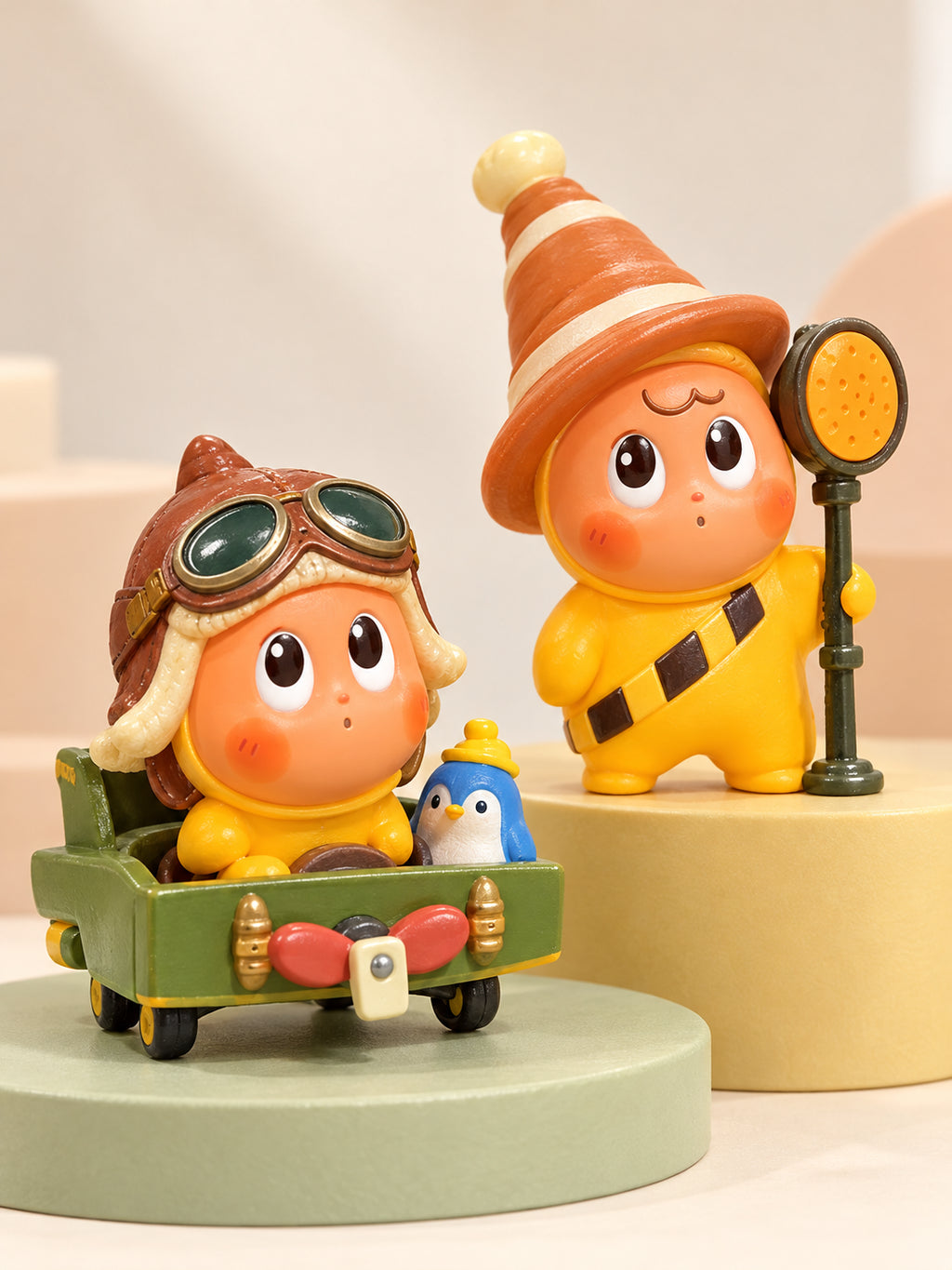 Star People aviator and yellow pointed-hat costume collectible figures on pastel display platforms